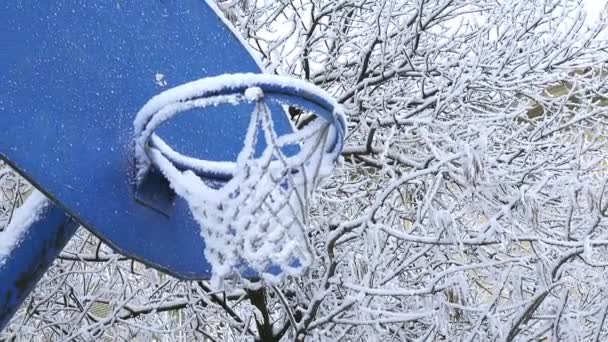 Neve coberto campo de jogos de basquete. Neve coberto arco de basquete — Vídeo de Stock