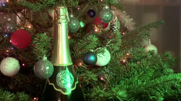 Sekt-Champagner unter dem mit Silvesterbällen geschmückten Tannenbaum — Stockvideo