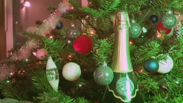 Mousserende wijn champagne onder de spar-kerstboom ingericht door New Years ballen — Stockvideo