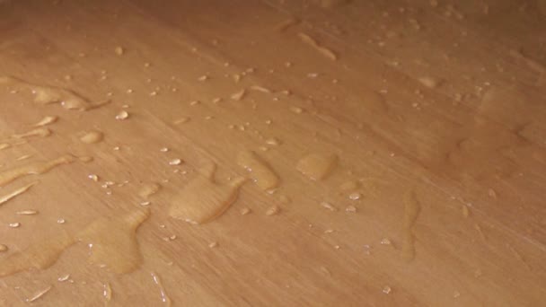 De rode roos valt op een houten tafel in water spatten — Stockvideo