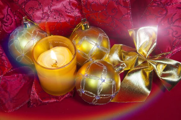 La composición de Año Nuevo sobre el fondo rojo - la bola y la cinta y la vela — Foto de Stock