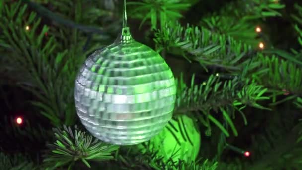Neujahrsball vor dem Hintergrund der geschmückten Girlande eines Weihnachtsbaums — Stockvideo