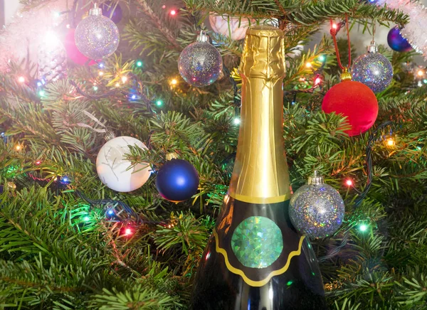 Nový rok koule na nový rok strom a obrovský láhev šumivého vína — Stock fotografie
