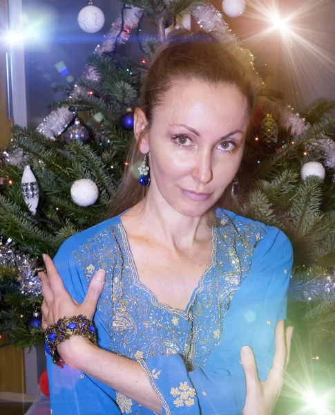 El retrato de la mujer joven feliz contra el árbol de Año Nuevo — Foto de Stock