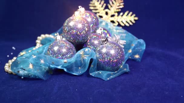 Bolas de Año Nuevo y cinta sobre un fondo azul — Vídeo de stock