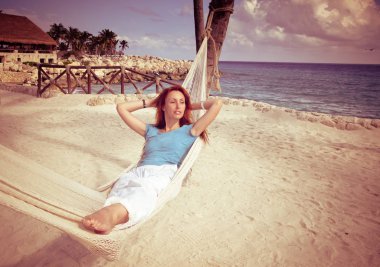 kadın okyanus ve gökyüzü, arka plan üzerinde hamakta tonlama