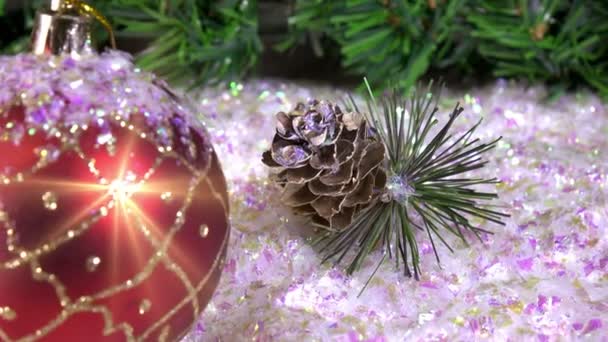 Le palle di anno nuovo si trovano su neve sullo sfondo di un abete di Natale — Video Stock