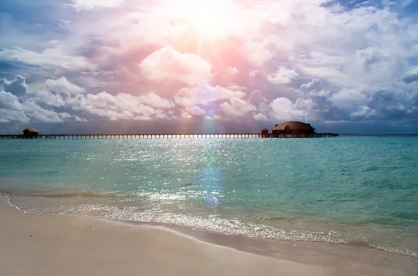 Maldive. Il mare turchese al sole e il ponte di legno sull'acqua — Foto Stock