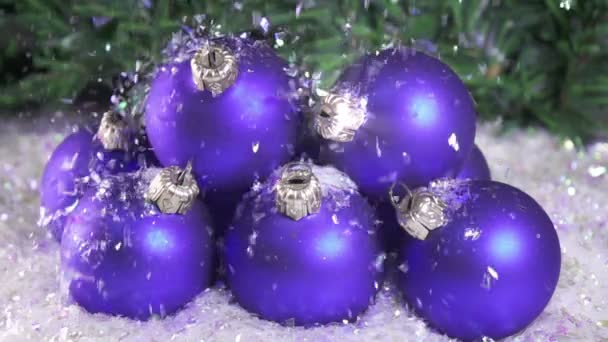 La neige tombe lentement sur les boules du Nouvel An sur fond de sapin de Noël. au ralenti — Video