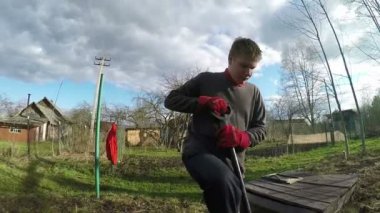 Genç adam yatak için bir kürek toprak kazıyor. Erken Bahar. Ağır çekim