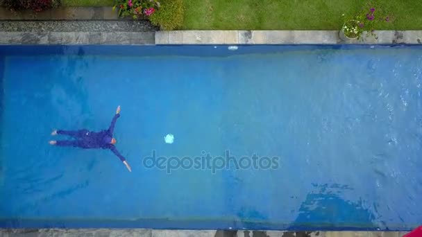 Attractive woman in a Muslim swimwear burkini swims in the pool — Stock Video