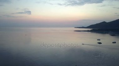 Taşlı sahil ve dağların üzerinde bir gün batımı. Endonezya. Drone görünümünden Bali.Aerial