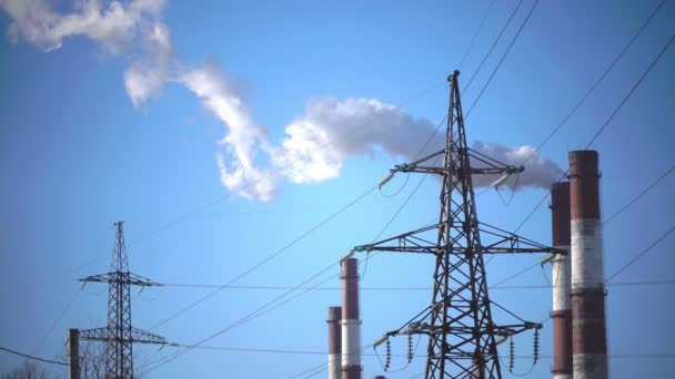 Industriële landschap. elektriciteitsleiding en rook van buizen van gecombineerde warmte- en krachtcentrale — Stockvideo