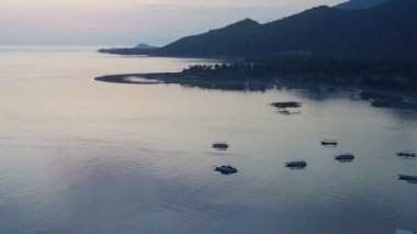 Dron, taşlı sahil ve dağların hava manzara bir günbatımı üzerinde. Endonezya. Bali.