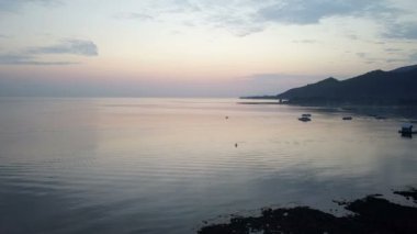 Dron, taşlı sahil ve dağların hava manzara bir günbatımı üzerinde. Endonezya. Bali.