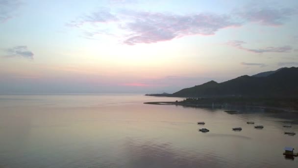 Vista aérea desde el dron, la costa pedregosa y las montañas al atardecer. Indonesia. Bali. . — Vídeo de stock