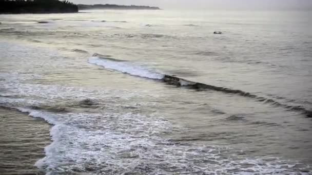 Wellen des Meeres rollen an der steinigen Küste, bali, Indonesien — Stockvideo