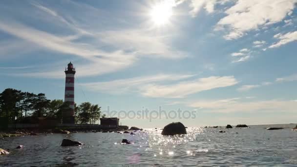 海岸的一座灯塔，时间推移与海太阳的天空上飘过的云 — 图库视频影像