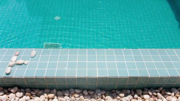 La inscripción "vacaciones" está dispuesta por guijarros en un lado de la piscina, stop-motion — Vídeos de Stock