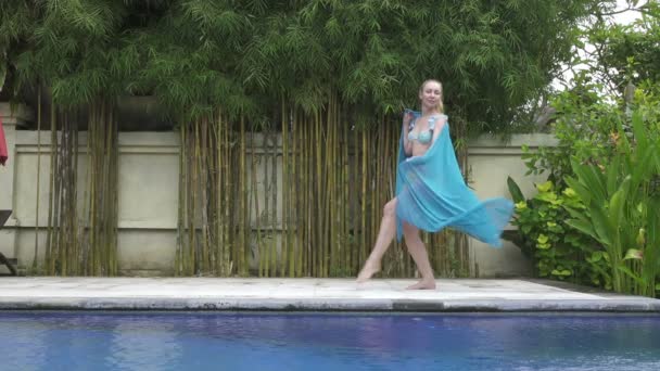 Jeune femme mince danse une danse orientale près de la piscine dans une station tropicale — Video