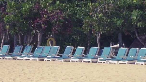 Panorama sur un certain nombre de chaises longues vides debout sur la plage de sable de la station tropicale — Video