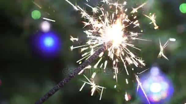 Bengala la luz sobre el fondo de un árbol de Navidad con bolas de Año Nuevo, cámara lenta — Vídeos de Stock