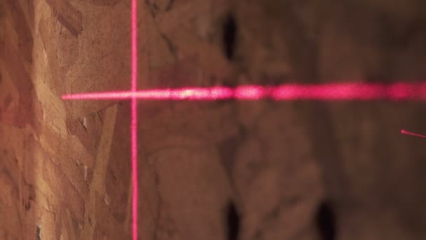 Nível de laser de construção e linhas vermelhas de uma marcação em uma superfície de parede — Vídeo de Stock