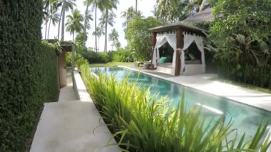 Bali, Endonezya, Kasım, 2016: Tropikal tatil köyü havuz palmiye ağaçları ve şezlong ile topraklarının bir görünüm