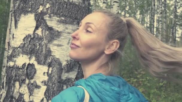 Portret van de jonge vrouw met een lange eerlijke haren in de berken hout, slow-motion — Stockvideo