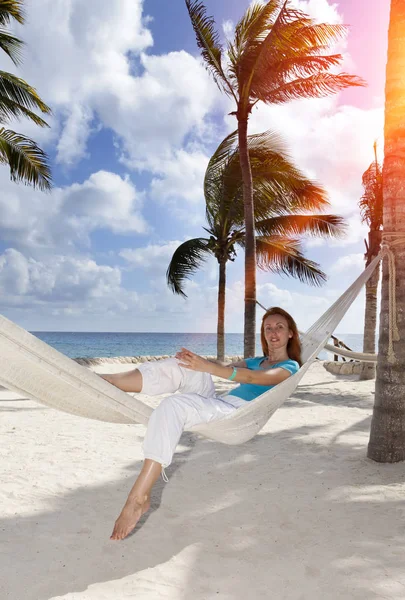 Arka plan mavi bir deniz üzerinde hamakta kadın