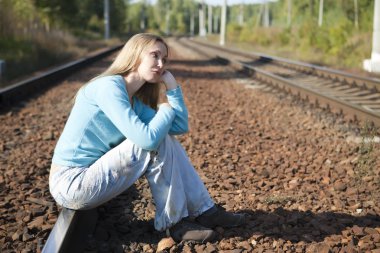 Kadın raylar üzerinde oturur