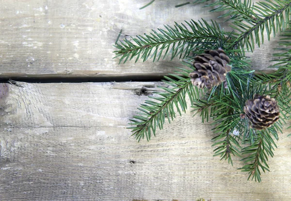 圣诞节和新年的概念 木制木板上有球果的冷杉树枝 顶部视图 — 图库照片