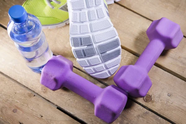 Turnschuhe Hanteln Trinkwasser Auf Holzgrund — Stockfoto