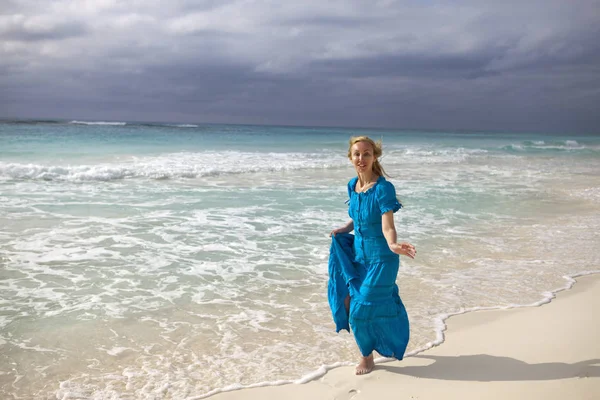 一个穿着蓝色长裙的女人去了岛拉拉岛上的海边海岸 — 图库照片
