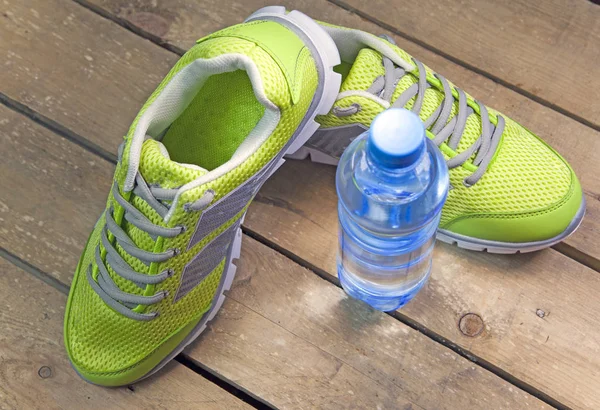 Zapatillas Deportivas Agua Potable Sobre Fondo Madera —  Fotos de Stock