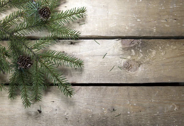 圣诞节和新年的概念 木制木板上有球果的冷杉树枝 顶部视图 — 图库照片