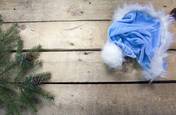 圣诞节和新年的概念 冷杉树分支与锥体和圣诞老人的帽子在木板上 顶部视图 — 图库照片