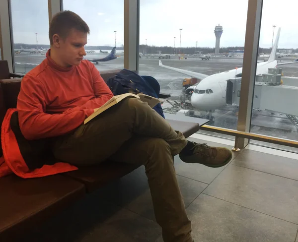 Lotnisko Poczekalnia Młody Człowiek Czyta Książkę — Zdjęcie stockowe