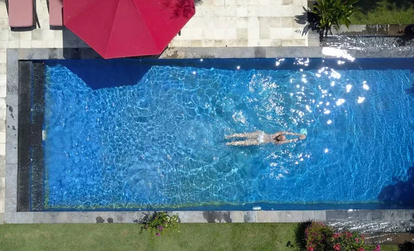 The young beautiful woman  in the pool, flat lay,view from drone