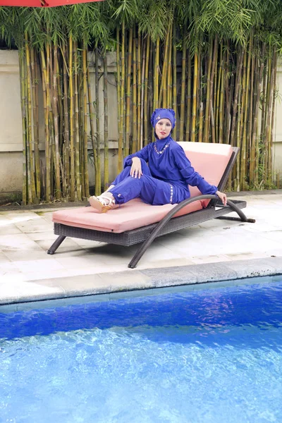 迷人的女人在一个穆斯林泳装 Burkini 在海滩板条床附近的大便 — 图库照片
