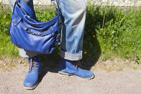 Γυναικεία Πόδια Μπλε Τζιν Και Μπότες Μια Μπλε Τσάντα Φόντο — Φωτογραφία Αρχείου