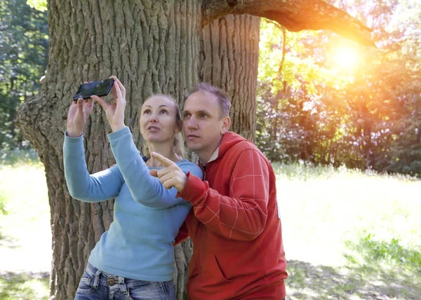 Hombre Mujer Cerca Roble Día Verano Aparecen Fotografía Por Teléfono —  Fotos de Stock