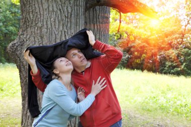 adam ve kadın bir yağmur meşe bir gizle yaz günü yakın: