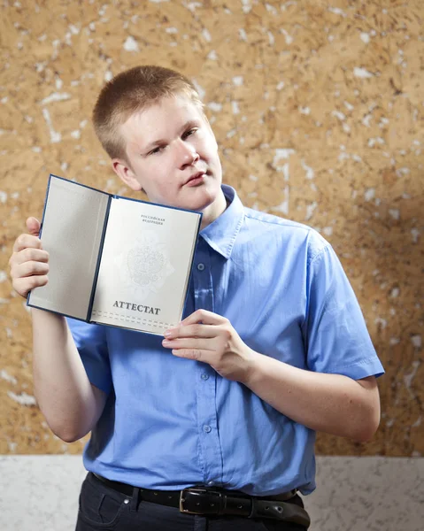 schoolboy with the certificate about completion of education at school (an inscription the certificate in Russian)