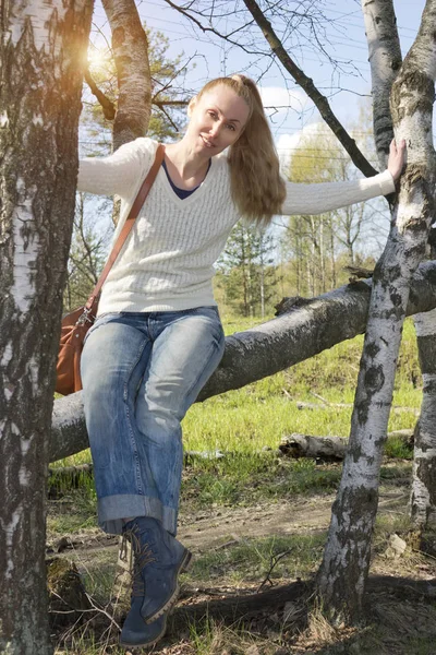 Junge Frau Sitzt Auf Einem Stamm Der Umgestürzten Birke — Stockfoto