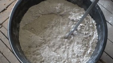 İnşaatçı, kuru inşaat karışımı, alçı, el yapımı karıştırıcı, onarım ve inşaat malzemelerini karıştırarak 4K Uhd 'da çekim yapıyor.