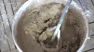 Alçılı bir kovada inşaat mikseri.