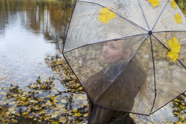 秋天的一天 女人在河边的一把透明的雨伞下 — 图库照片