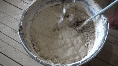 İnşaatçı kuru inşaat karışımı, alçı, elle inşa karıştırıcı, onarım ve inşaat, yavaş çekim karışımını karıştırıyor.