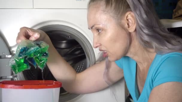 Young woman prepare to wash in washing machine and opens box with washing powder And emotionally responds to fact that the average for washing is not qualitative and spoiled,Shot in 4K — ストック動画